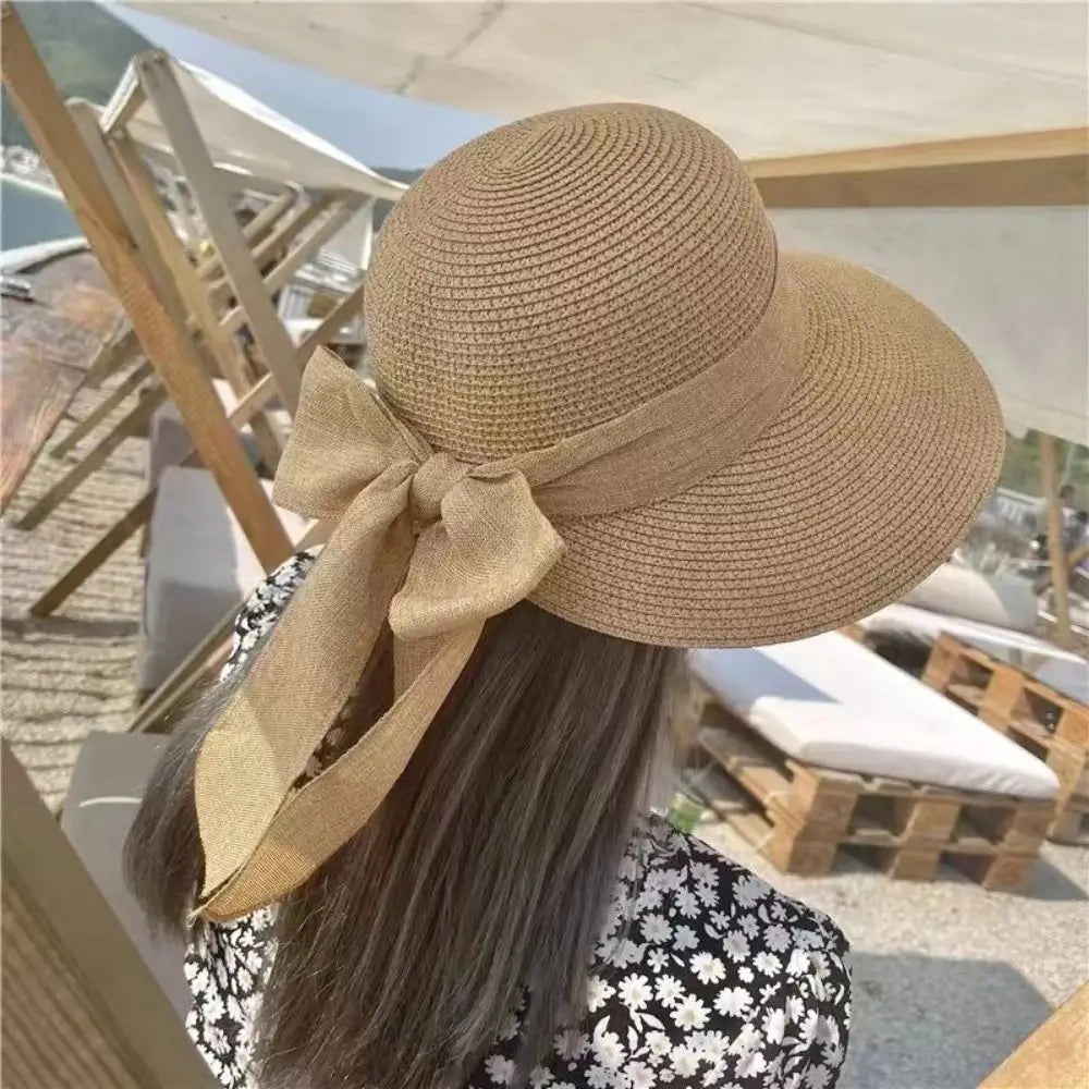 giornate di sole. Questo elegante cappello estivo a falda larga, impreziosito da un bellissimo nastro a fiocco sul retro, è l'accessorio indispensabile per le tue vacanze. Leggero, fresco e chic, non solo ti ripara dal caldo